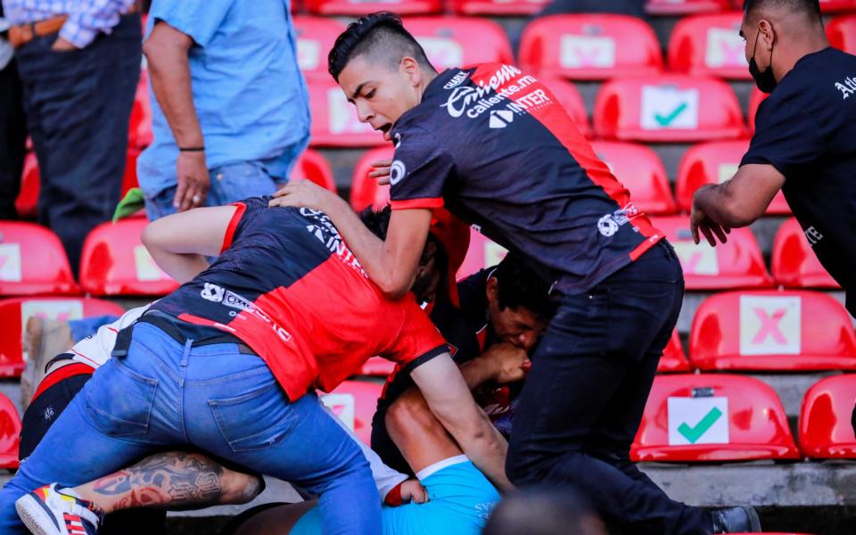 People are beaten at the seating area of the Corregidora stadium, leaving at least 22 injured in a brawl when soccer fans stormed the field during a top-flight match between mid-table Queretaro and last year's Liga MX champions Atlas, in Queretaro, Mexico - REUTERS