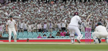 Fans dressed as late cricket player and commentator Richie Benaud wear suits, grey wigs and prop microphones, as they pay tribute to him during the third cricket test between Australia and the West Indies at the SCG in Sydney, January 4, 2016. REUTERS/Jason Reed