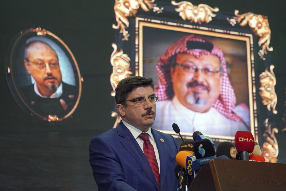 FILE - In this Sunday, Nov. 11, 2018 file photo, Yasin Aktay, an advisor to Turkey's President Recep Tayyip Erdogan, speaks during an event organized to mark the 40th day of the death of Saudi writer Jamal Khashoggi, background, in Istanbul, Turkey. Saud Al-Mojeb, Saudi Arabia’s top prosecutor, is recommending the death penalty for five suspects charged with ordering and carrying out the killing of Saudi writer Jamal Khashoggi. Al-Mojeb told a press conference in Riyadh Thursday, Nov. 15, 2018, that Khashoggi’s killers had been planning the operation since September 29, three days before he was killed inside the kingdom’s consulate in Istanbul. (AP Photo/Neyran Elden, File)