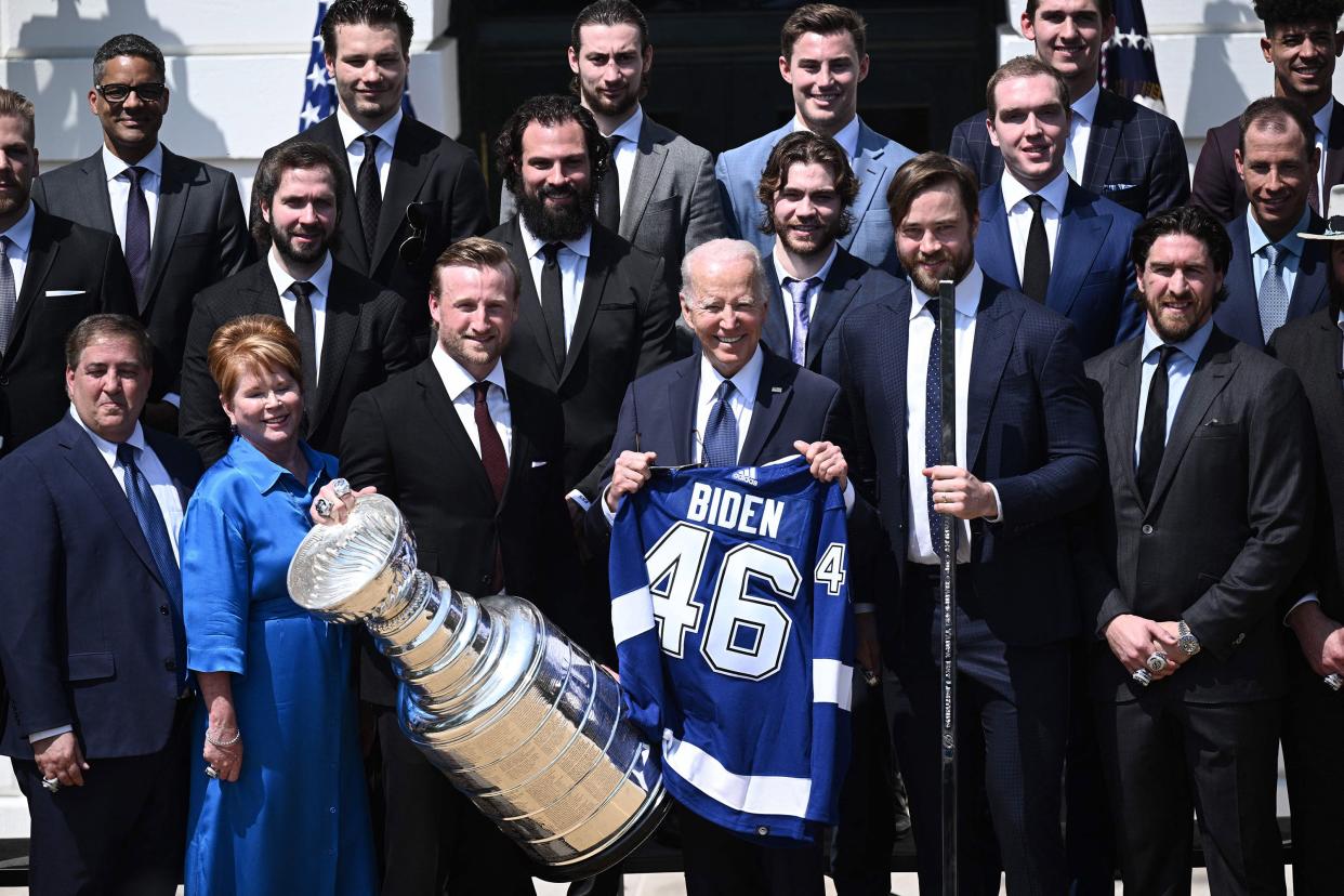 U.S. President Joe Biden holds a jersey bearing his name as he poses with members of the 2020-2021 Stanley Cup champion Tampa Bay Lightning hockey team during a ceremony honoring the team on the South Lawn of the White House in Washington, DC on April 25, 2022.