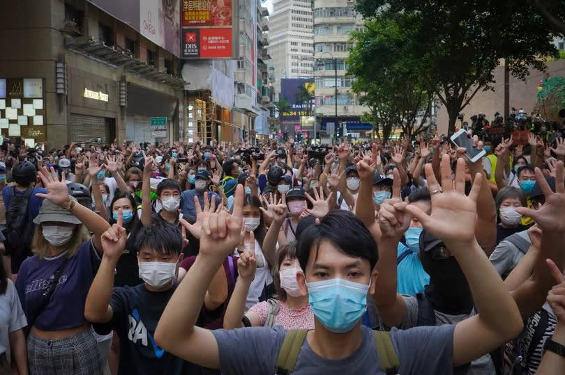 Protesters against the new national security law march and gesture with five fingers, signifying the "five demands - not one less" on the anniversary of Hong Kong's handover to China from Britain in Hong Kong, Wednesday, July. 1, 2020 -Credit:AP