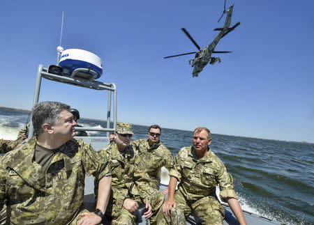 Ukraine's President Petro Poroshenko (L) inspects a military drill with the Secretary of the National Security and Defense Council of Ukraine Oleksandr Turchynov (2nd L), in the waters of the Black Sea in Mykolaiv region, Ukraine, in this July 21, 2015 file photo. REUTERS/Mykola Lazarenko/Ukrainian Presidential Press Service/Handout via Reuters/Files