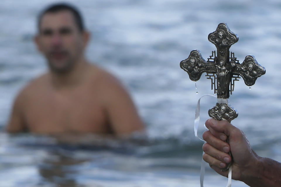 A swimmer holds the cross after it was thrown by an Orthodox priest into the water, during an epiphany ceremony to bless the sea at Famagusta in the Turkish Cypriots breakaway north part of the eastern Mediterranean divided island of Cyprus, Monday, Jan. 6, 2020. Many Orthodox Christian faithful attended the Epiphany Day blessing of the waters in Famagusta in Cyprus', the fifth time the ceremony has taken place since 1974 when the small island nation was cleaved along ethnic lines. (AP Photo/Petros Karadjias)