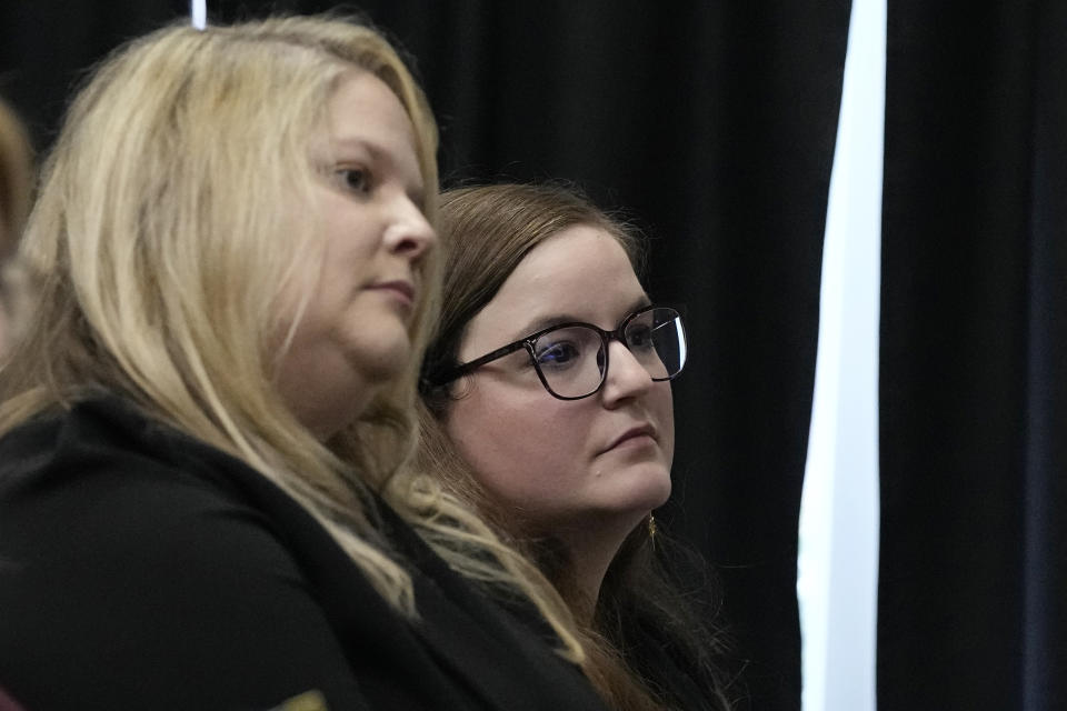 Caroline Hunt, cener, and Tessa Henry, right, with the Attorney General's office, listen during a clemency hearing for death row inmate Scott Eizember, Wednesday, Dec. 7, 2022, in Oklahoma City. Eizember was convicted in the shotgun slayings of an elderly couple in eastern Oklahoma in 2003. (AP Photo/Sue Ogrocki)