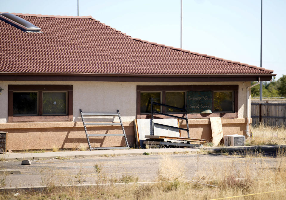 A sign covers the broken back window of the Return to Nature Funeral Home in Penrose, Colo., Monday, Oct. 16, 2023. The remains of at least 189 decaying bodies were found and removed from the Colorado funeral home, up from about 115 reported when the bodies were discovered two weeks ago, officials said Tuesday, Oct. 17. (AP Photo/David Zalubowski)