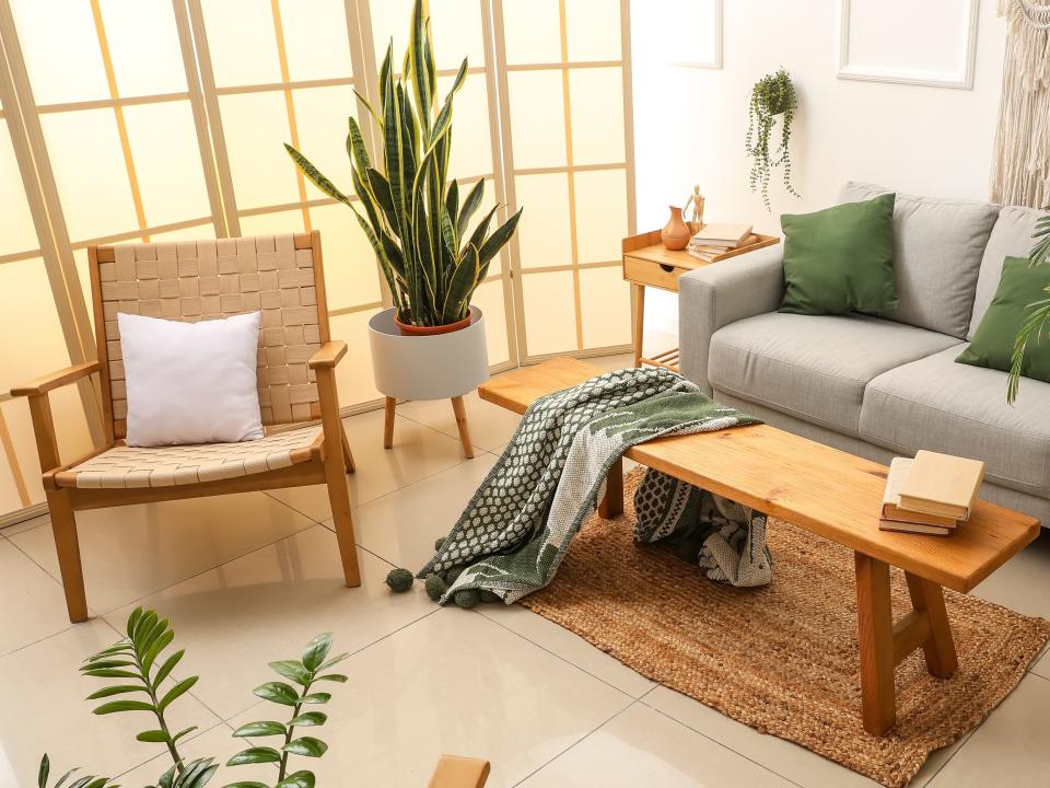 A room filled with wooden furniture, plants, and boho influences