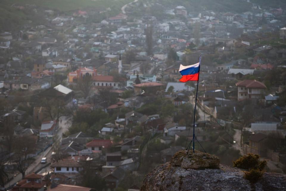 In this March 28, 2014 file photo, a Russian national flag flies on a hilltop near the city of Bakhchysarai, Crimea. The Group of Seven major industrialized countries on Thursday March 18, 2021, issued a strong condemnation of what it called Russia's ongoing “occupation” of the Crimean Peninsula, seven years after Moscow annexed it from Ukraine. ((AP Photo/Pavel Golovkin, File))