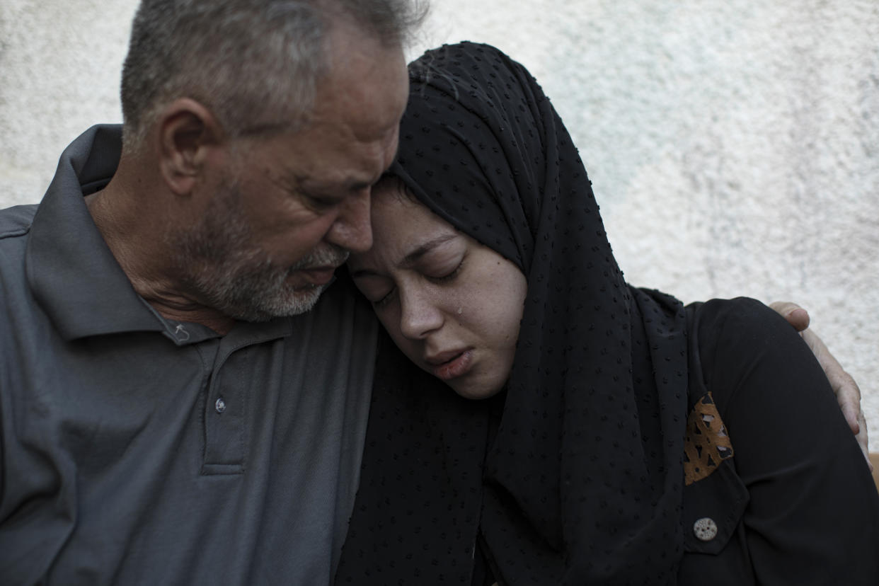 Relatives of Ismail Dweik, who was killed in an Israeli airstrike, mourn before his funeral, outside a hospital in Rafah, in the southern Gaza Strip, Sunday, Aug. 7, 2022. An Israeli airstrike in Rafah killed a senior commander in the Palestinian militant group Islamic Jihad, authorities said Sunday, its second leader to be slain amid an escalating cross-border conflict. (AP Photo/Fatima Shbair)