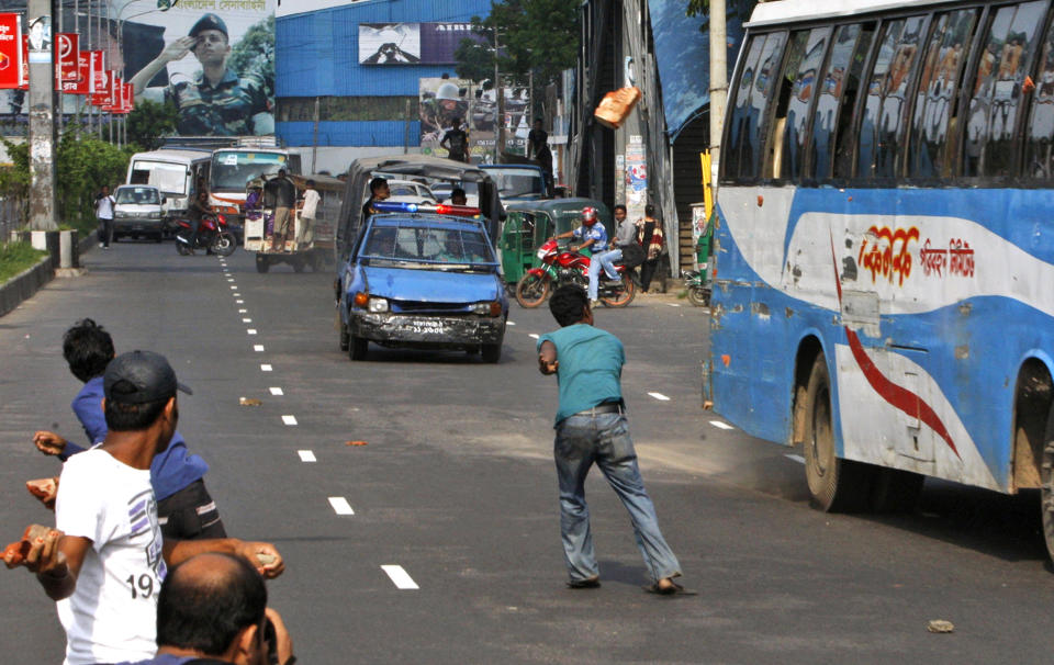 FILE - In this April 29, 2012 file photo, Bangladeshi opposition activists throw stones at vehicles during a nationwide general strike against the abduction of opposition politician Elias Ali in Dhaka, Bangladesh. The abduction of Ali and his driver as they returned home from meeting supporters at a hotel on April 17, 2012, has sparked one of Bangladesh's biggest crisis in years. The clashes have reignited hostilities between Prime Minister Sheikh Hasina and her archrival Khaleda Zia, who have alternated in power since a pro-democracy movement ousted the last military regime in 1990. (AP Photo/Pavel Rahman, File)