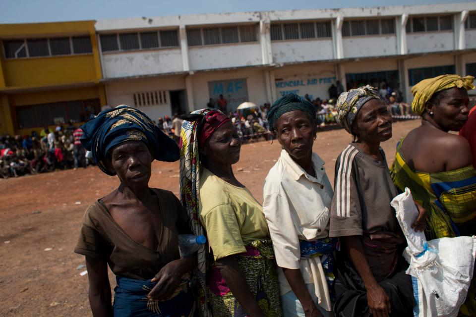 Elderly women wait in line to receive food and supplies, at an aid distribution point inside a makeshift camp housing an estimated 100,000 displaced people, at Mpoko Airport in Bangui, Central African Republic, Wednesday, Jan. 8 2014. The distribution by the World Food Program and the United Nations Refugee Agency began Tuesday and was expected to last 10 days. It is the first aid delivery to reach the camp since Dec. 15, and many families were lacking food or even rudimentary shelter from the harsh daytime sun and chilly nights. Residents were receiving supplies including rice, cooking oil, tarps, mats, and blankets. (AP Photo/Rebecca Blackwell)