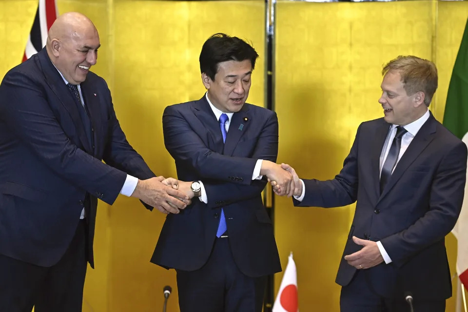 Britain's Defense Minister Grant Shapps, right, Italy's Defense Minister Guido Crosetto, left, and Japanese Defense Minister Minoru Kihara, center, shake hands prior a trilateral meeting at the defense ministry Thursday, Dec. 14, 2023, in Tokyo, Japan. (David Mareuil/Pool Photo via AP)