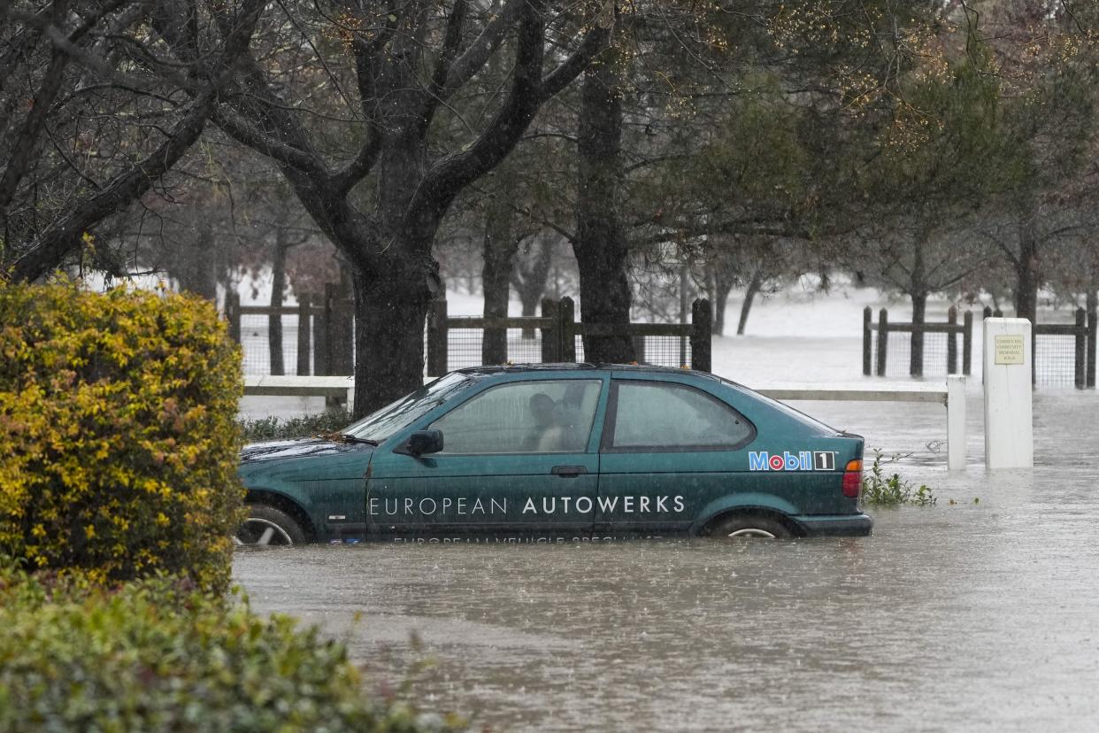 A car lies semi-submerged in flood waters at Camden on the outskirts of Sydney, Australia, Monday, July 4, 2022.