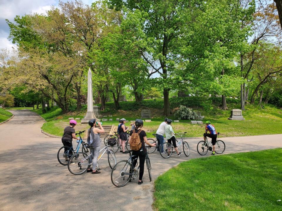 A tour group is shown at the Elmwood Cemetery in Detroit during a Wheelhouse Detroit biking Underground Railroad tour.