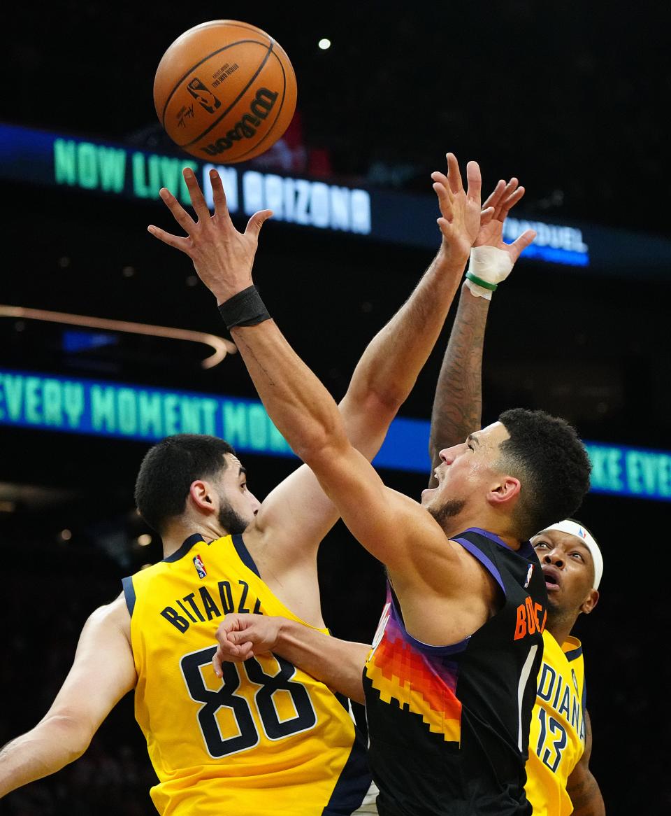 Jan 22, 2022; Phoenix, Arizona, USA; SunsÕ Devin Booker (1) goes up for a lay-up against PacerÕs Goga Bitadze (88) during the first half at the Footprint Center. Mandatory Credit: Patrick Breen-Arizona Republic