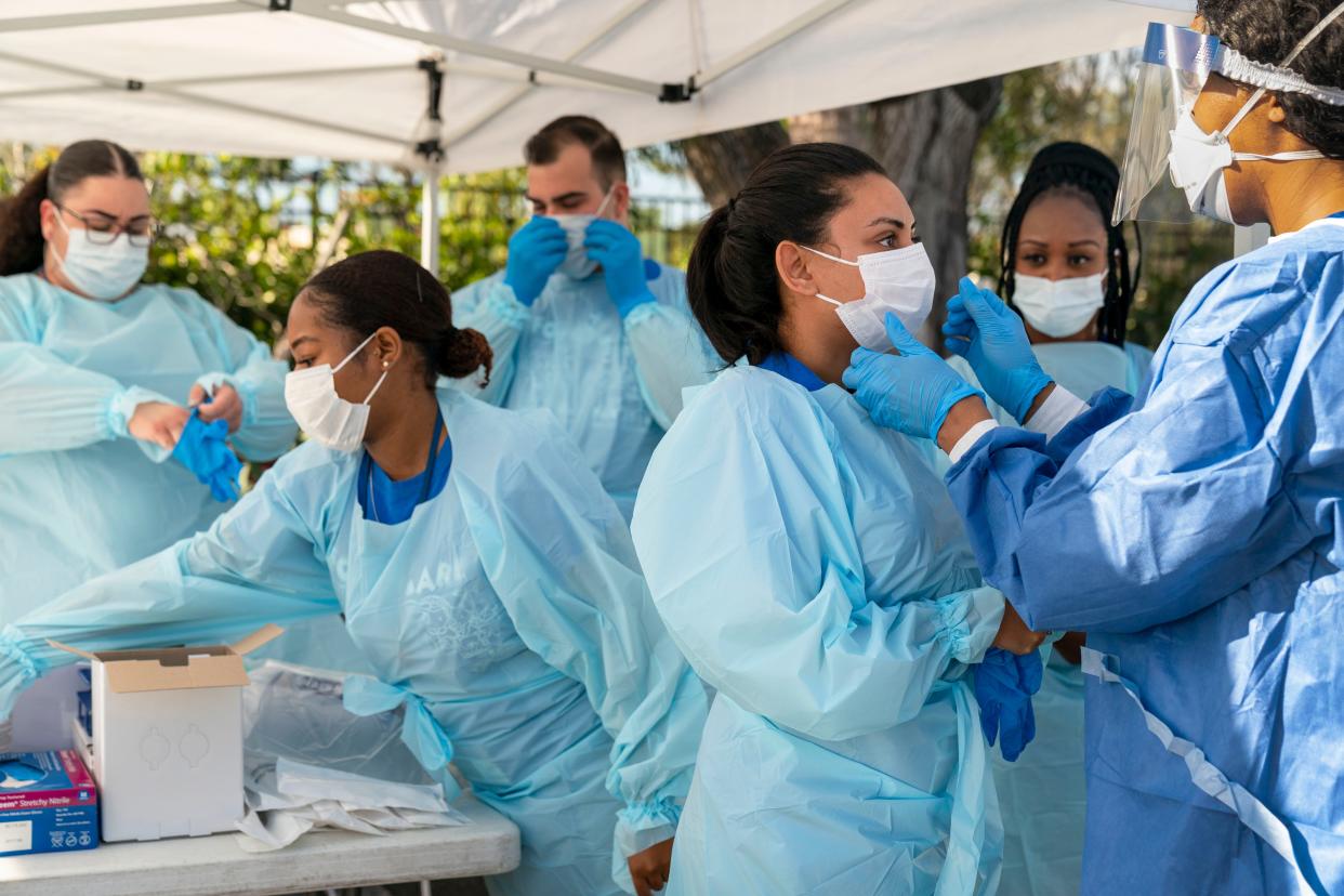 A medical team prepares to test people for the coronavirus at a drive-thru station in a parking lot in West Palm Beach, Fla., on March, 16, 2020.