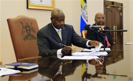 Uganda President Yoweri Museveni signs an anti-homosexual bill into law at the state house in Entebbe, 36 km (22 miles) south west of capital Kampala February 24, 2014. REUTERS/James Akena