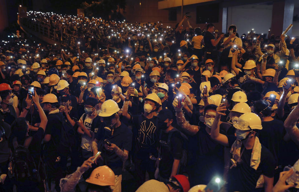 Protesters hold up their mobile phone lights as they surround the police headquarters in Hong Kong on Friday, June 21, 2019. Several hundred mainly student protesters gathered outside Hong Kong government offices Friday morning, with some blocking traffic on a major thoroughfare, after a deadline passed for meeting their demands related to controversial extradition legislation that many see as eroding the territory's judicial independence. (AP Photo/Kin Cheung)