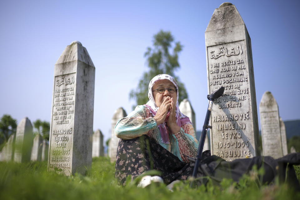 A Bosnian muslim woman mourns next to the graves of her children and husband, victims of the Srebrenica genocide, at the Memorial Centre in Potocari, Bosnia, Tuesday, July 11, 2023. Thousands gather in the eastern Bosnian town of Srebrenica to commemorate the 28th anniversary on Monday of Europe's only acknowledged genocide since World War II. (AP Photo/Armin Durgut)