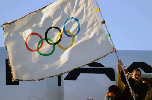 Rio de Janeiro Mayor Eduardo Paes waves the Olympic flag at the Tom Jobim International Airport in Rio de Janeiro upon arrival from London. Paes stepped off a plane carrying the flag, accompanied by Carlos Arthur Nuzman, president of the 2016 Games Organizing Committee and Rio Governor Sergio Cabral