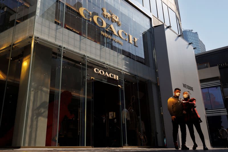 FILE PHOTO: People walk past a store of the Coach luxury fashion retailer in a shopping district in Beijing