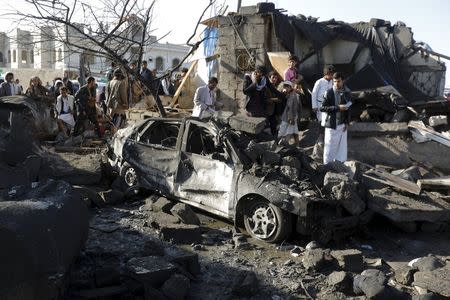 People gather at the site of an air strike at a residential area near Sanaa Airport March 26, 2015. REUTERS/Khaled Abdullah