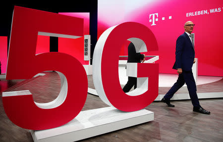 Timotheus Hoettges, CEO of Deutsche Telekom AG, walks on stage past a 5G technology setup during the company's annual shareholder meeting in Bonn, Germany March 28, 2019. REUTERS/Wolfgang Rattay