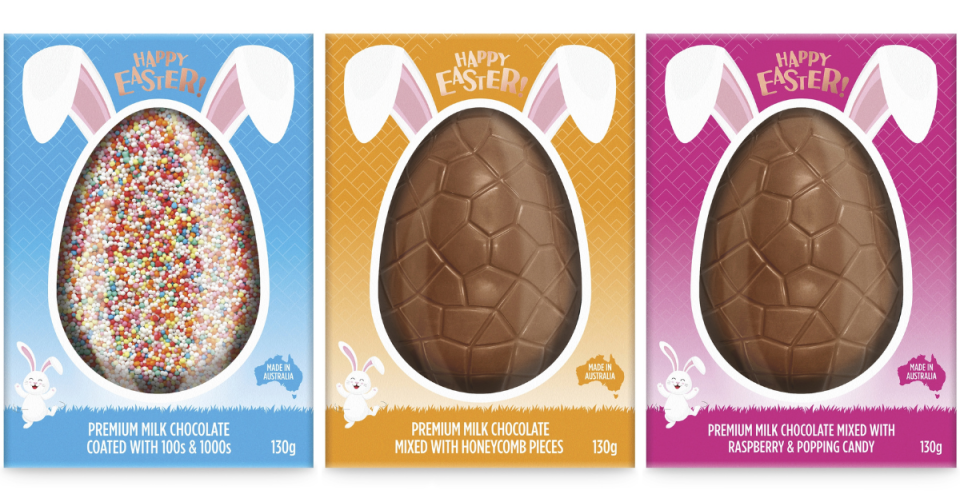 Three large eggs in boxes, one with sprinkles and the others milk chocolate.