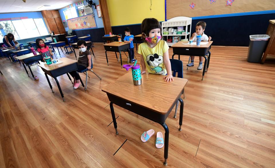 Children in a preschool class wear masks and sit at desks spaced apart as per coronavirus guidelines during summer school sessions in Monterey Park, California, on July 9.