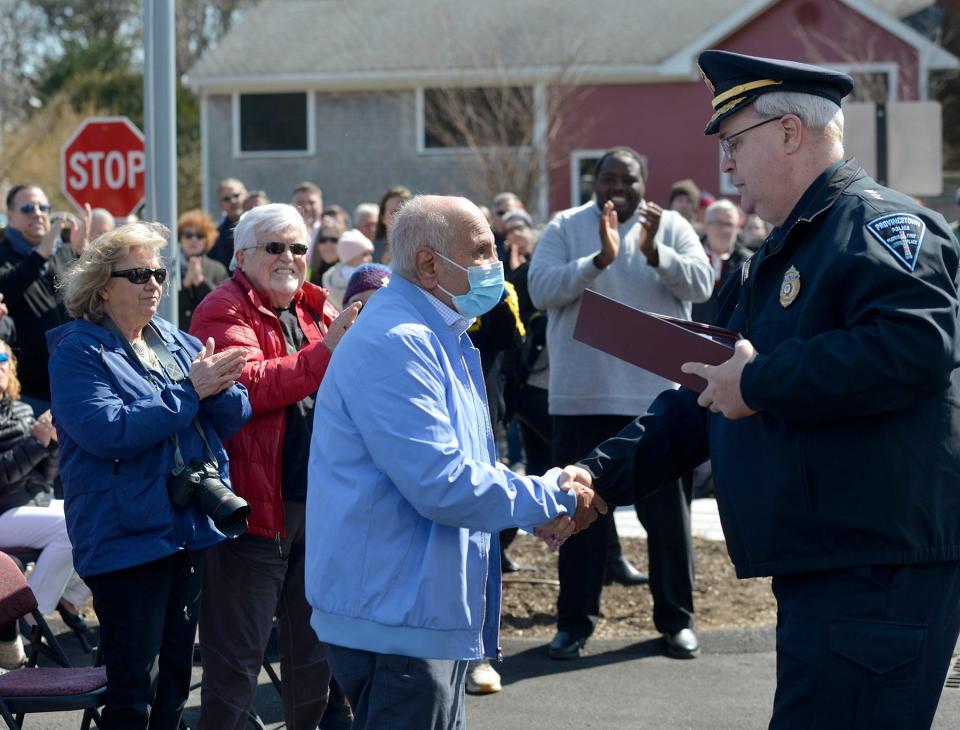 At the new police station on Wednesday, Provincetown Police Chief James Golden, right, presents retired Police Chief Robert Anthony with the American flag that was lowered from the existing station. The new police station will open April 4.