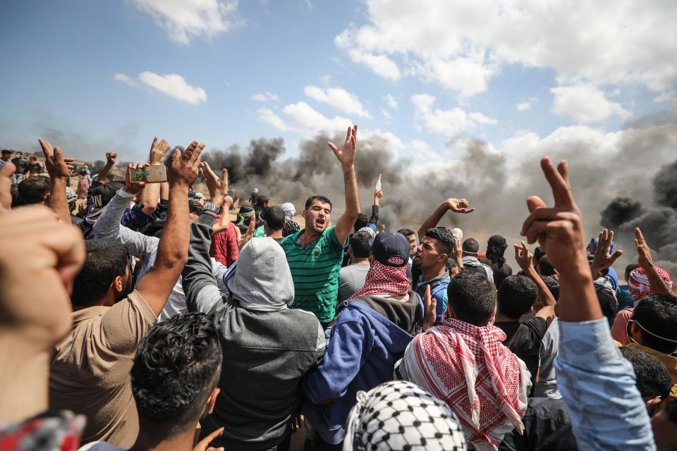 <p>Palestinians carry an injured protester after Israel’s intervention during a protest to mark the 70th anniversary of Nakba, also known as Day of the Catastrophe in 1948, and against the relocation of the U.S. Embassy from Tel Aviv to Jerusalem, near Gaza-Israel border in Khan Younis on May 14, 2018. (Photo: Mustafa Hassona/Anadolu Agency/Getty Images) </p>