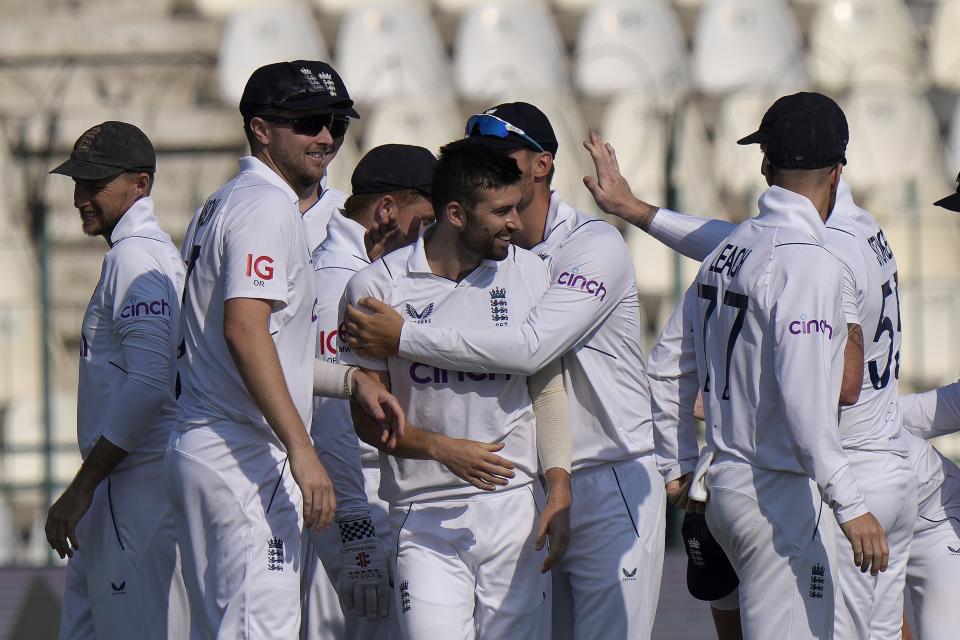 England's Mark Wood, center, celebrates with teammates after the dismissal of Pakistan's Saud Shakeel during the fourth day of the second test cricket match between Pakistan and England, in Multan, Pakistan, Monday, Dec. 12, 2022. (AP Photo/Anjum Naveed)