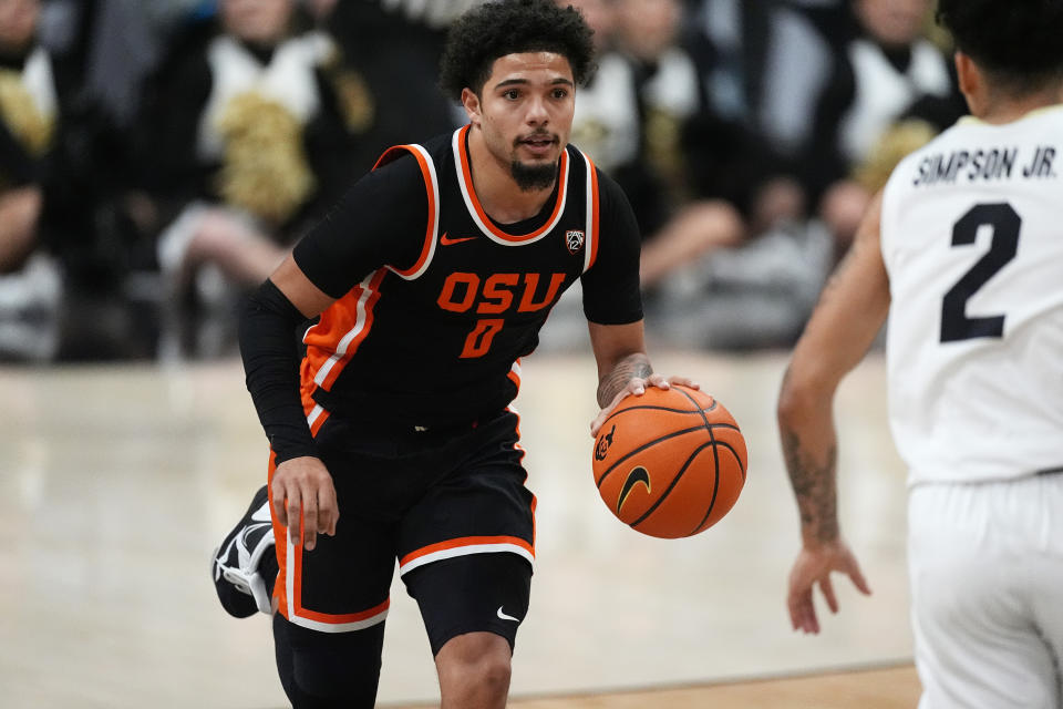 Oregon State guard Jordan Pope, left, drives upcourt as Colorado guard KJ Simpson, right, drops back to defend in the first half of an NCAA college basketball game Saturday, Jan. 20, 2024, in Boulder, Colo. (AP Photo/David Zalubowski)