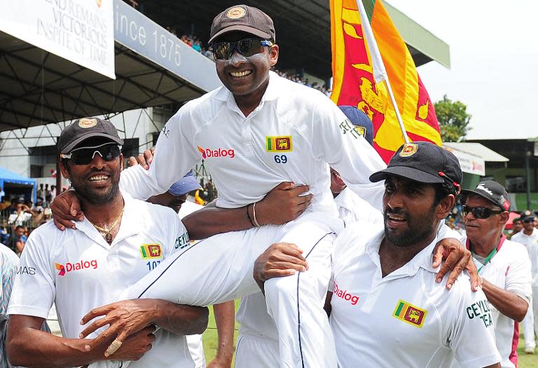 Sri Lanka's Mahela Jayawardene (C) smiles as teammates Chanaka Welegedara (L) and Dhammika Prasad (R) carry him around the pitch in a lap of honour at the Sinhalese Sports Club (SSC) Ground in Colombo on August 18, 2014