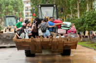 <p>Students are transferred by a forklift through a flooded area at a college in Guilin, Guangxi province, China, July 3, 2017. (Photo: Stringer/Reuters) </p>