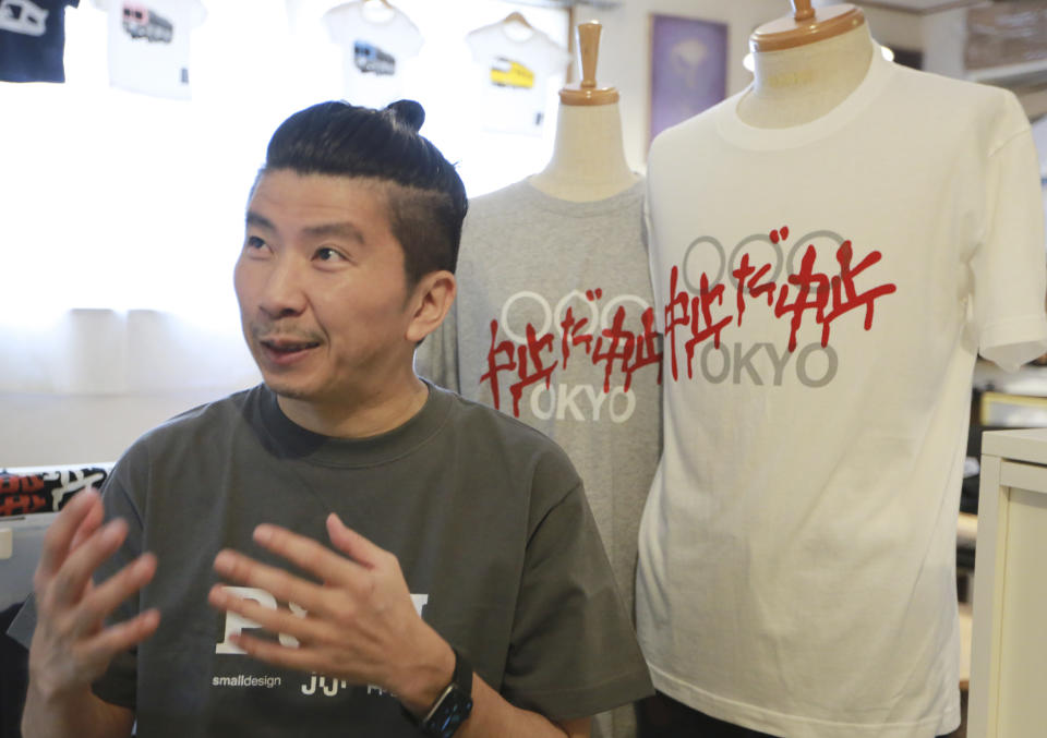 Designer Susumu Kikutake speaks during an interview with the Associated Press in Tokyo, Wednesday, June 9, 2021. An online article showcasing his design calling for the Olympics to be cancelled resulted in harsh online comments, and he sold only around 10 shirts a month before the pandemic. But demand for the t-shirts has boomed in the past two months, with sales reaching 100 shirts in April and 250 in May. The characters on the shirt read "Cancelation, Cancelation". (AP Photo/Koji Sasahara)