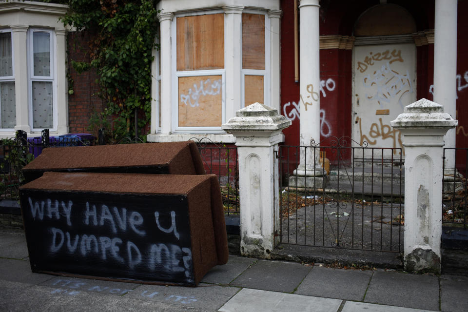 Grafitti covers a discarded sofa as it lies on the pavement outside a boarded up house in Liverpool, northern England September 21, 2013. REUTERS/Phil Noble (BRITAIN - Tags: SOCIETY POVERTY REAL ESTATE BUSINESS)