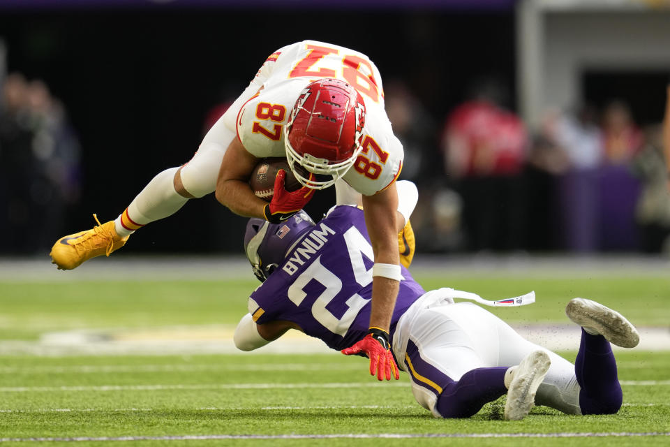 Kansas City Chiefs tight end Travis Kelce (87) is tackled by Minnesota Vikings safety Camryn Bynum (24) after catching a pass during the first half of an NFL football game, Sunday, Oct. 8, 2023, in Minneapolis. (AP Photo/Abbie Parr)