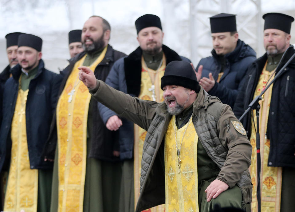 Orthodox priests bless people gathered to support independent Ukrainian church near the St. Sophia Cathedral in Kiev, Ukraine, Saturday, Dec. 15, 2018. Ukraine's Orthodox clerics gather for a meeting Saturday that is expected to form a new, independent Ukrainian church, and Ukrainian authorities have ramped up pressure on priests to support the move. (AP Photo/Efrem Lukatsky)