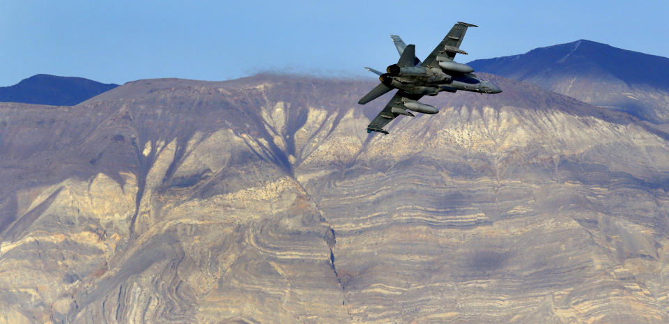 FILE - In this Feb. 27, 2017 file photo, an F/A-18D Hornet from the VX-9 Vampire squadron at Naval Air Weapons Station China Lake, flies out of what is known as Star Wars Canyon toward the Panamint range in Death Valley National Park, Calif. On Wednesday, July 31, 2019 a U.S. Navy F/A-18 Super Hornet jet crashed Wednesday in the California desert and a search-and-rescue operation was underway, officials said. The single-seat warplane went down at 9:50 a.m. during a routine training mission north of the China Lake base. (AP Photo/Ben Margot, File)