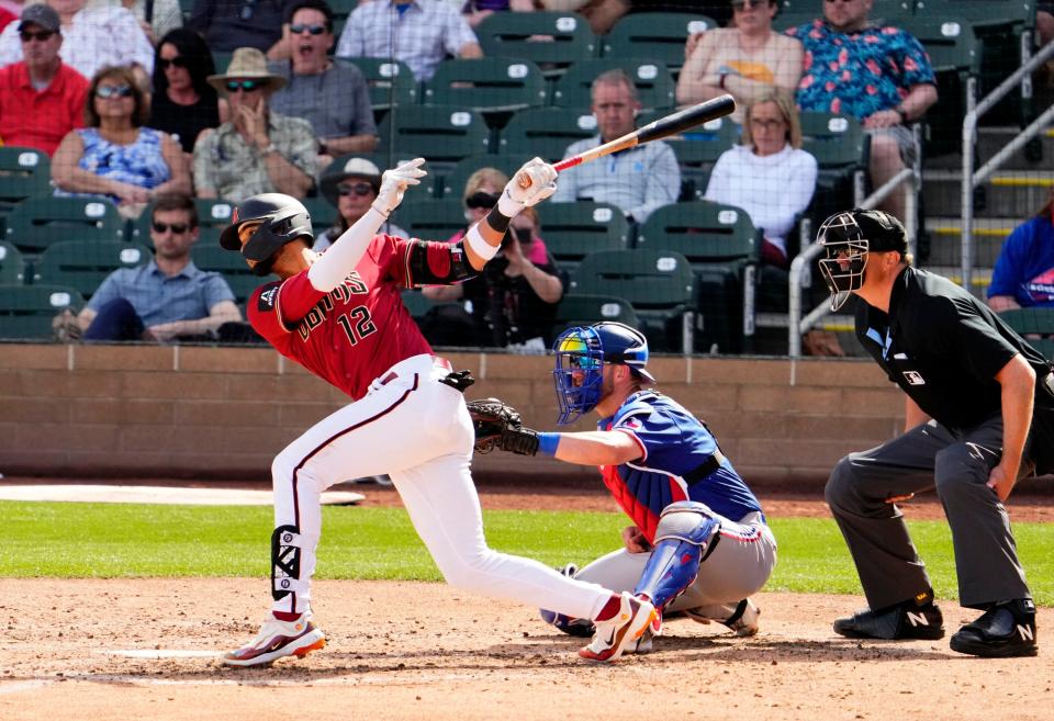 Arizona Diamondbacks Lourdes Gurriel Jr. (12) hits an RBI-single against the Texas Rangers in the sixth inning during a spring training game at Salt River Fields in Scottsdale on March 8, 2023.