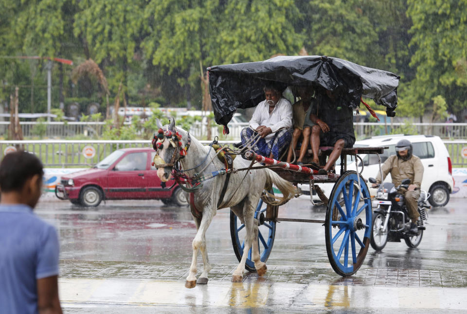 A horse cart ferries passengers in the rain in Prayagraj, in the northern Indian state of Uttar Pradesh, Wednesday, July 24, 2019. Lightning has killed more than 50 people in July, including more than 30 in Uttar Pradesh state, with thunderstorms and heavy rains lashing north and eastern India. South Asia's monsoon rains, which hit the region from June to September, are crucial for the rain-fed crops planted during the season. (AP Photo/Rajesh Kumar Singh)