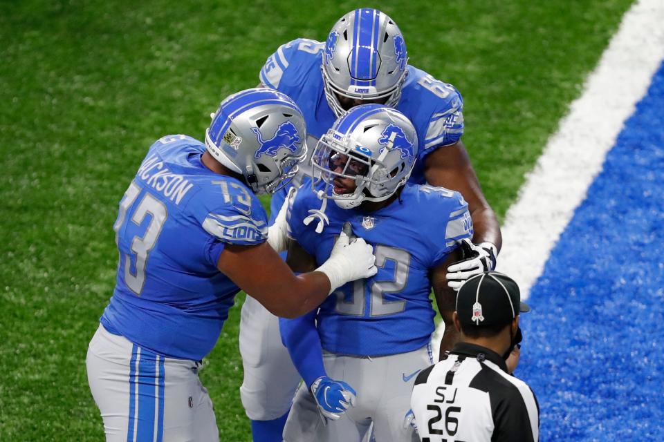 Lions running back D'Andre Swift gets congratulated by offensive guard Jonah Jackson, left, and offensive tackle Tyrell Crosby after scoring a touchdown during the third quarter at Ford Field on Sunday, Nov. 15, 2020.