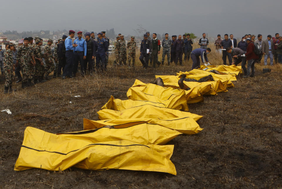 <p>Nepalese rescuers attend to bodies of victims after a passenger plane from Bangladesh crashed at the airport in Kathmandu, Nepal, March 12, 2018. (Photo: Niranjan Shreshta/AP) </p>