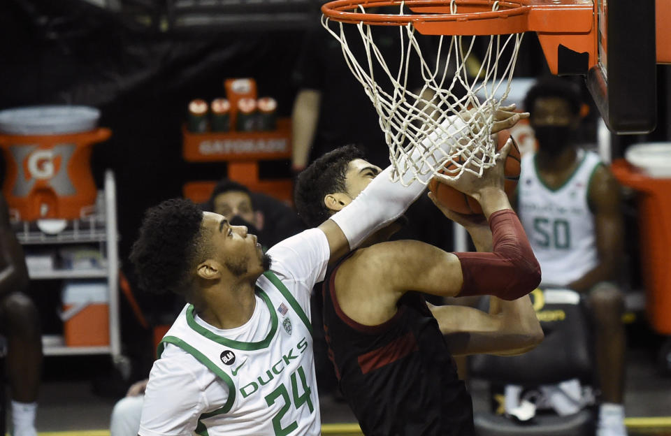 Oregon guard Aaron Estrada (24) challenges the shot of Stanford forward Jaiden Delaire (11) during the first half of an NCAA college basketball game Saturday, Jan. 2, 2021 in Eugene, Ore. (AP Photo/Andy Nelson)