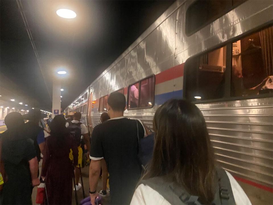 people lining up to board Amtrak train