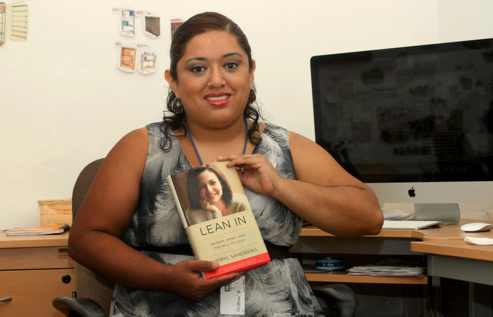 In this Aug. 12, 2013 photo, marketing executive Ana Falcon poses with a copy of Facebook COO Sheryl Sandberg's book "Lean In," in Monterrey, Mexico. Falcon is working to set up a Lean In circle, or small empowerment group for working women. The circles are inspired by Sandberg’s book, a manifesto for women in the workplace. Sandberg says that since the book was launched in March, more than 7,000 such circles have been formed, in all 50 states and in 50 countries. (AP Photo/Alfredo Lopez)