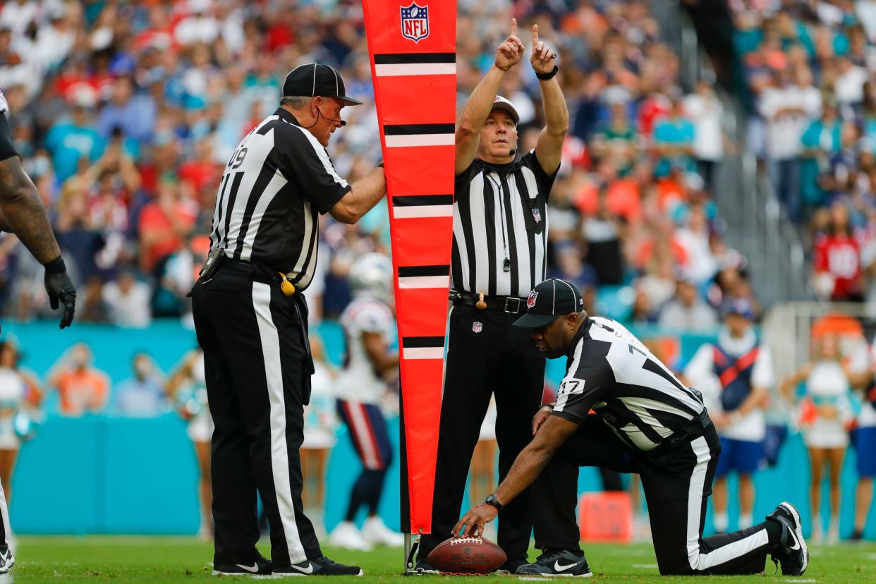 NFL officials measure the distance to a first down during a between the Dolphins and the Patriots.