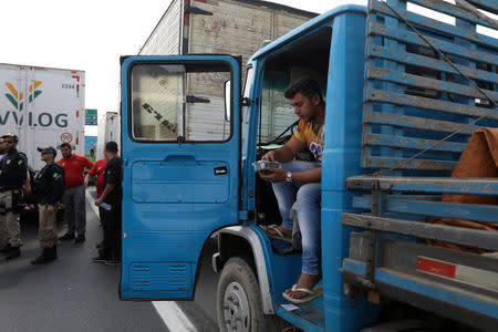 A trucker has lunch as truckers block the BR-040 highway during a protest against high diesel fuel prices in Duque de Caxias in Rio de Janeiro, Brazil May 24, 2018. REUTERS/Pilar Olivares