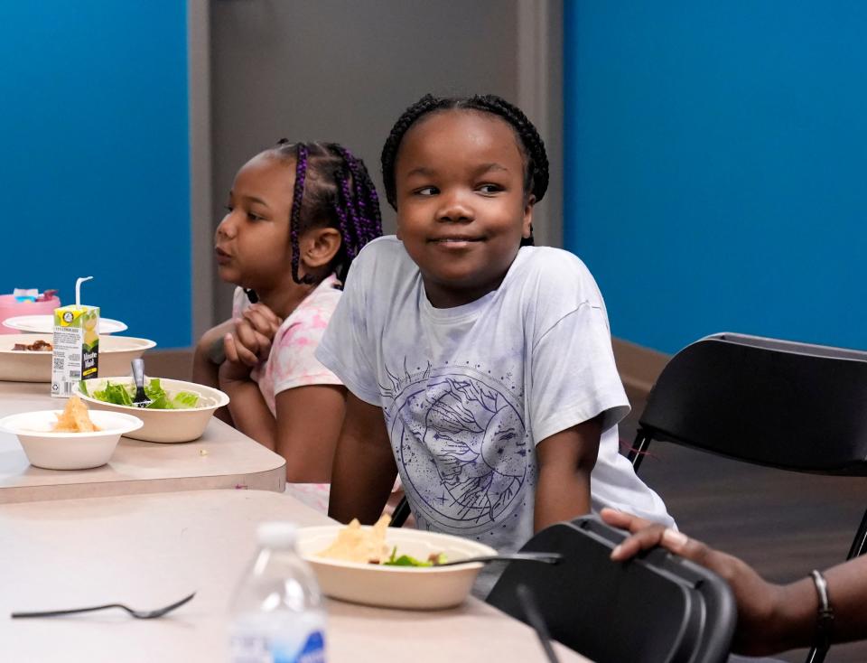 Skylar, left, and Payton, right, enjoy dinner and programming through the Columbus Scholar House. The girls and a dozen other children whose parents are Scholar House residents worked on vision boards to present at their end-of-the-semester celebration.