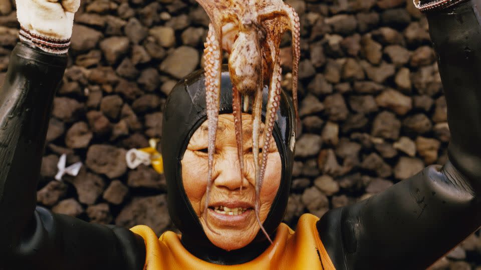 A Haenyeo diver shows off a small octopus, part of her catch. - Peter Ash Lee